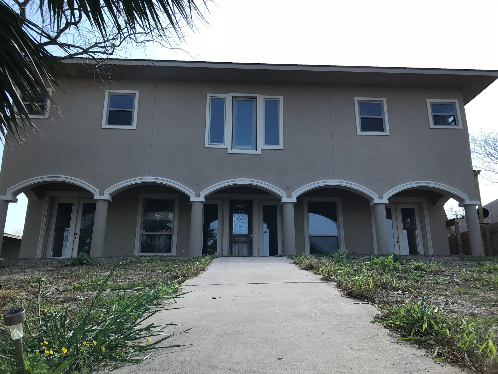 A large house with a concrete walkway leading to it