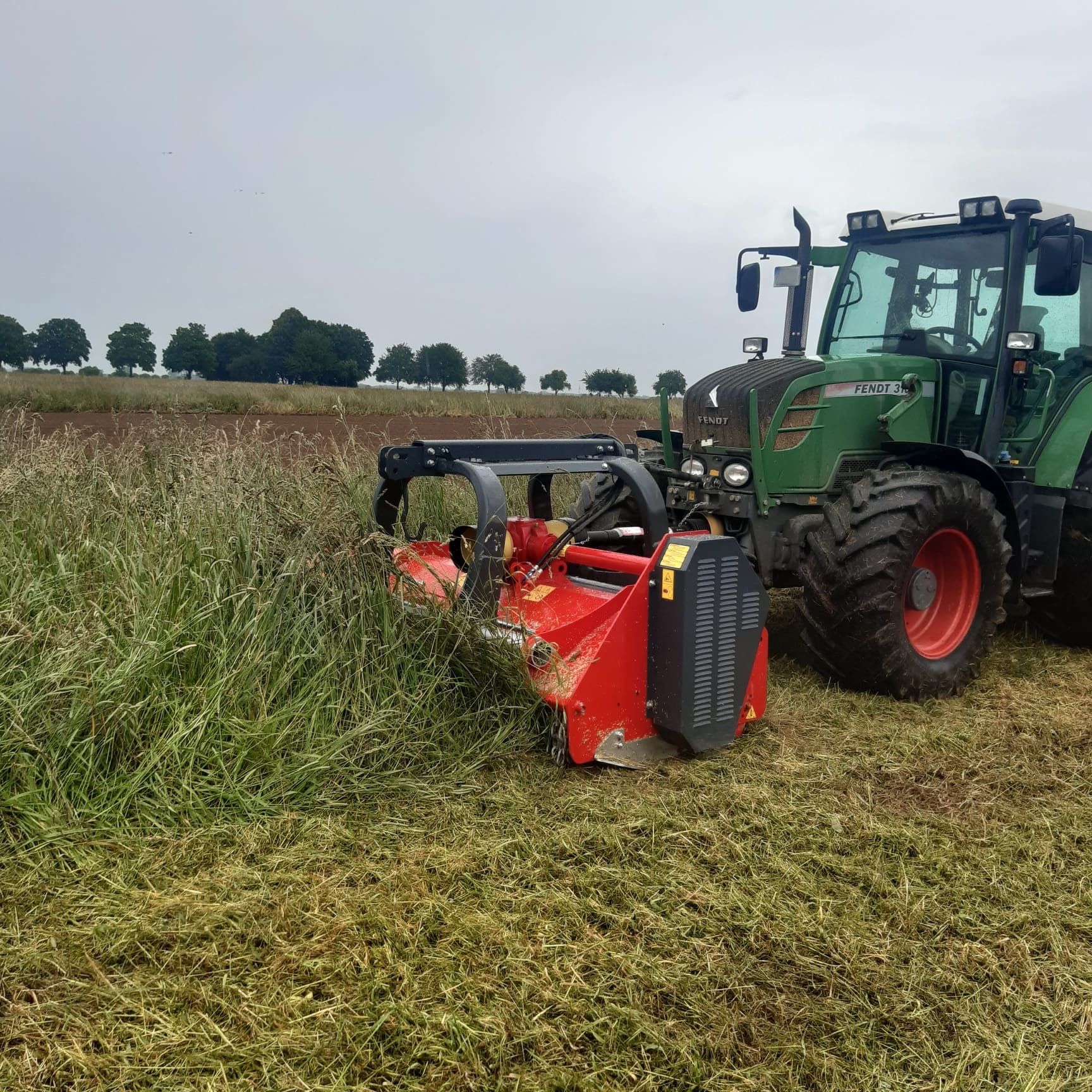 Ein roter Traktor steht am Straßenrand