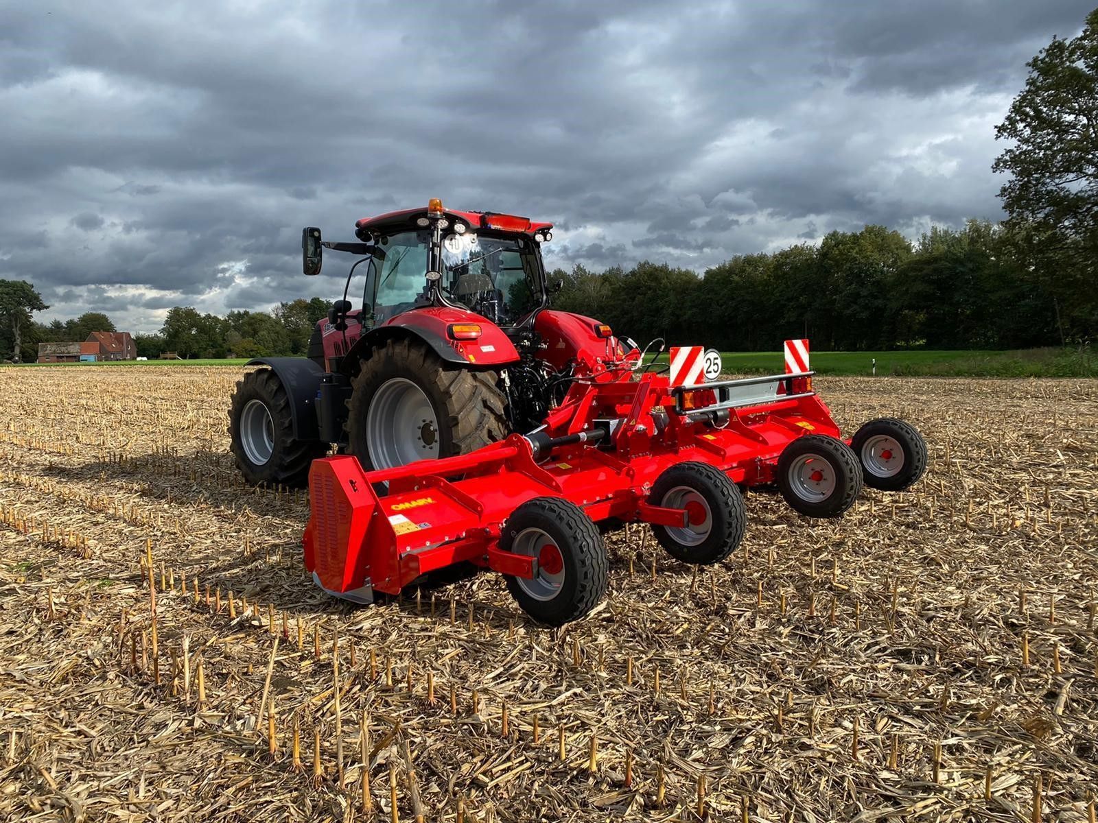 Ein gelber Traktor steht am Straßenrand.
