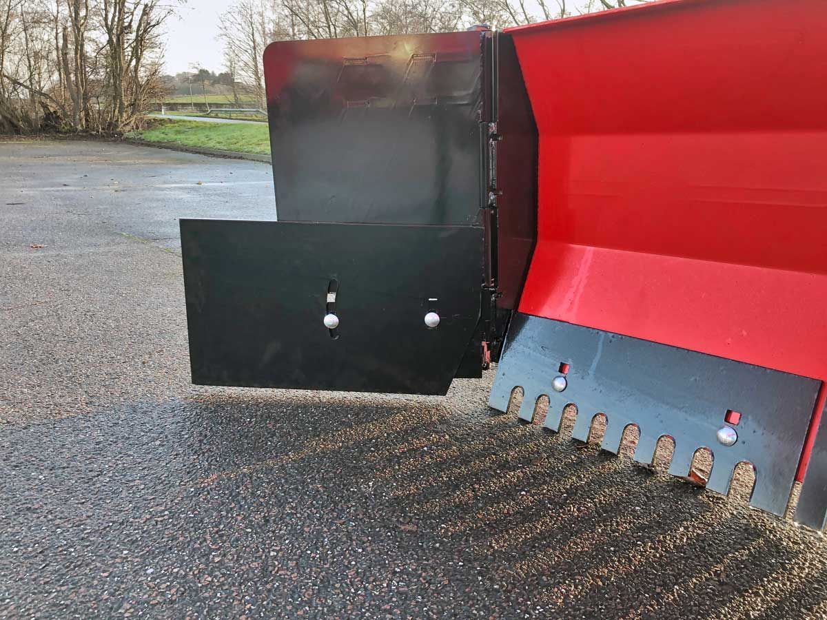 Am Straßenrand parkt ein rot-schwarzer Schneepflug.