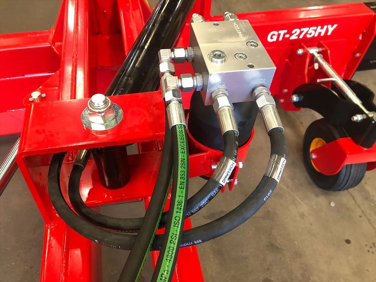 Ein roter Traktor mit daran befestigten Hydraulikschläuchen