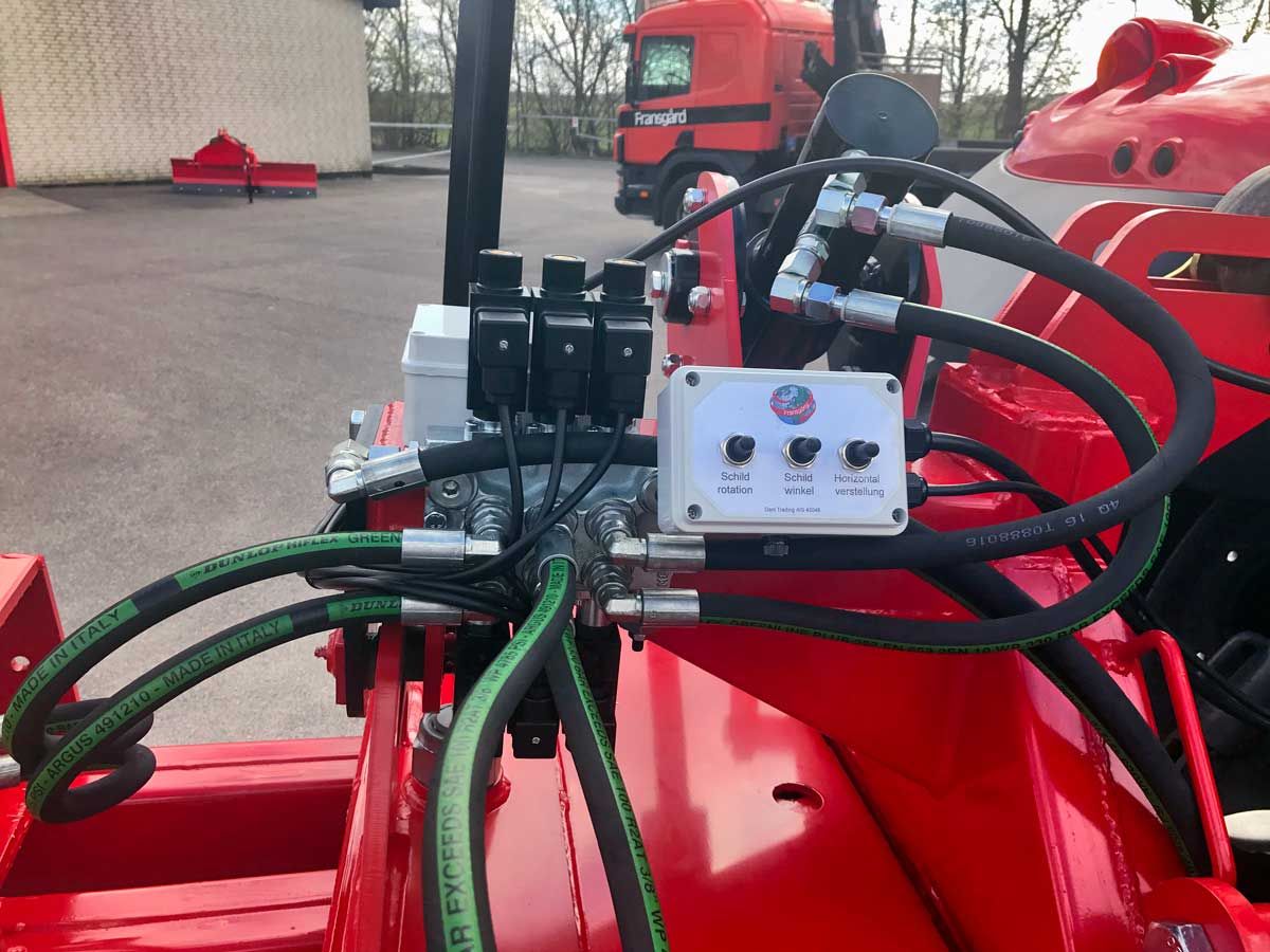 Ein roter Traktor mit daran befestigten Hydraulikschläuchen