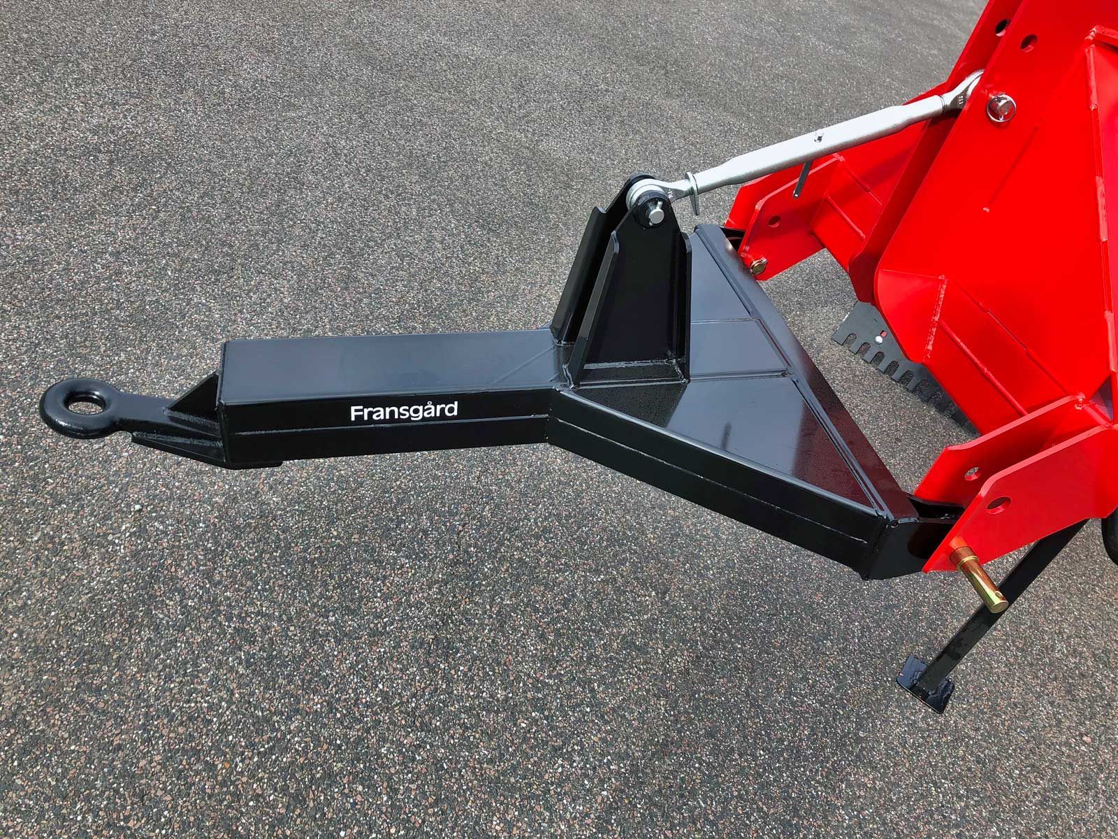 Ein roter Traktor mit einem schwarzen Anhänger