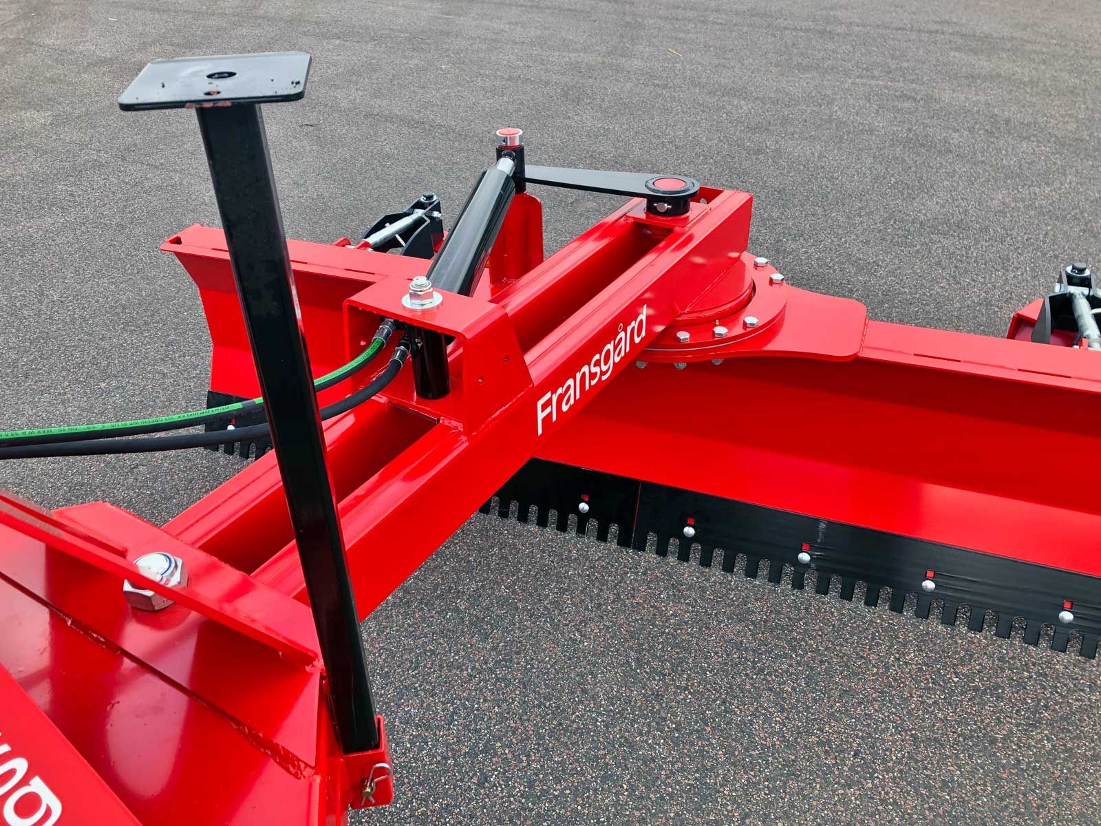Ein roter Traktor steht am Straßenrand.