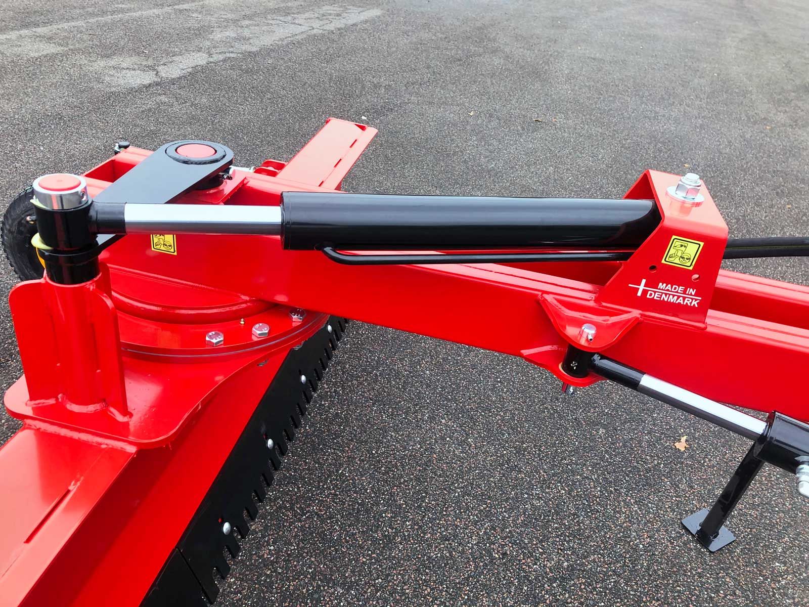 Ein roter Traktor steht am Straßenrand.
