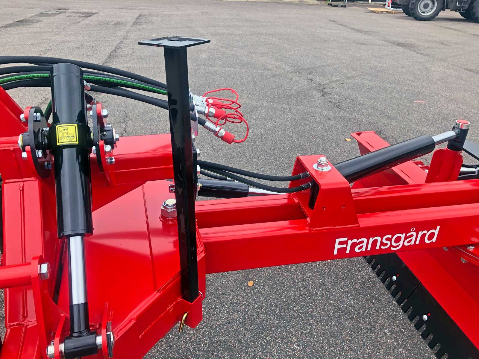 Ein roter Fransgard Traktor steht auf einem Parkplatz