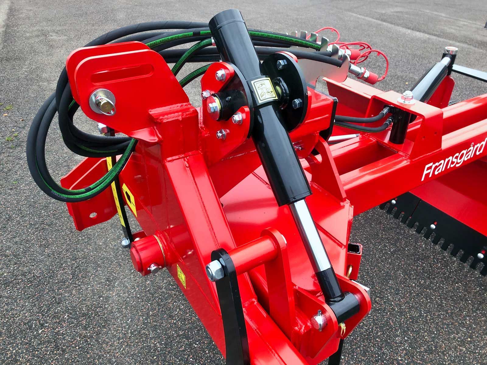 Ein roter Traktor steht am Straßenrand.