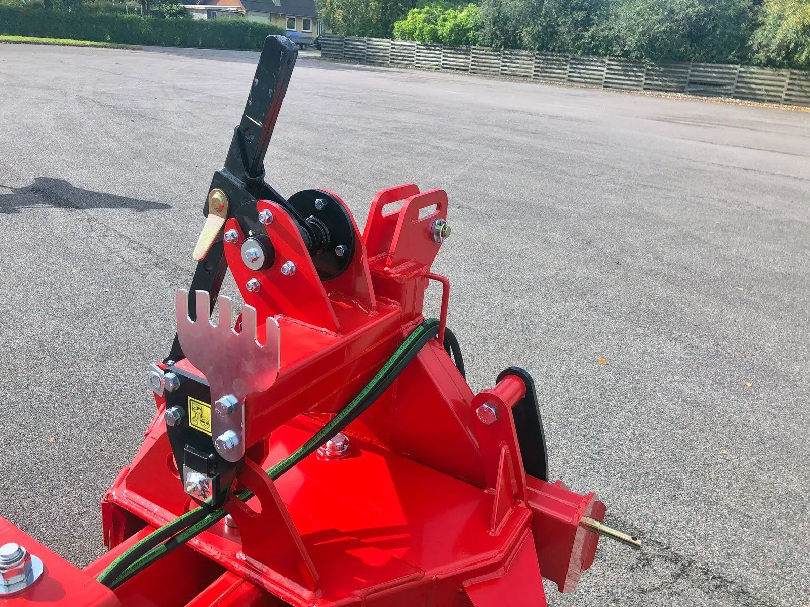Ein roter Traktor steht am Straßenrand.