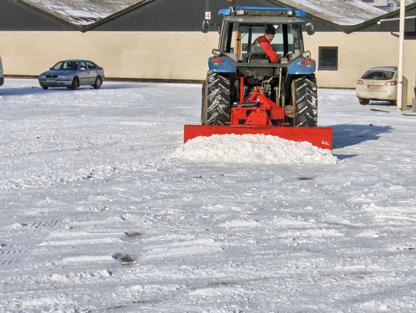 Ein Traktor räumt Schnee auf einem Parkplatz