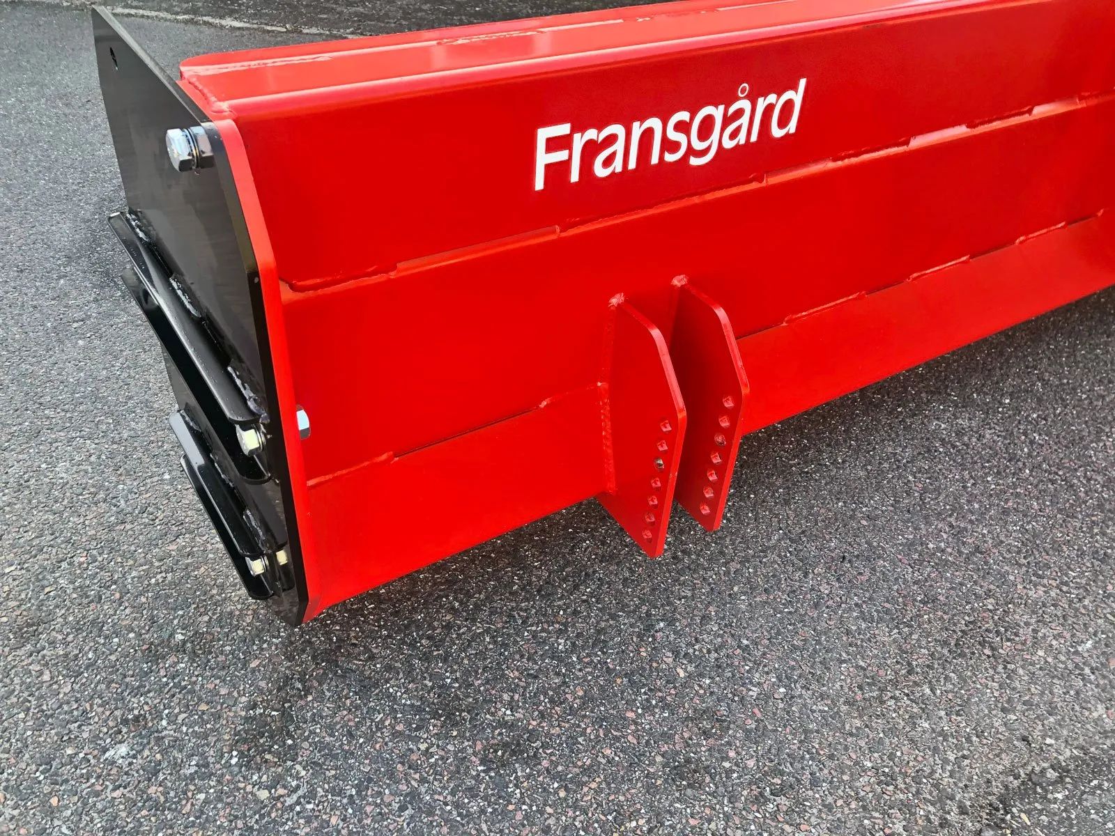 Auf dem Boden liegt ein rotes Frenchgard-Traktorblatt.