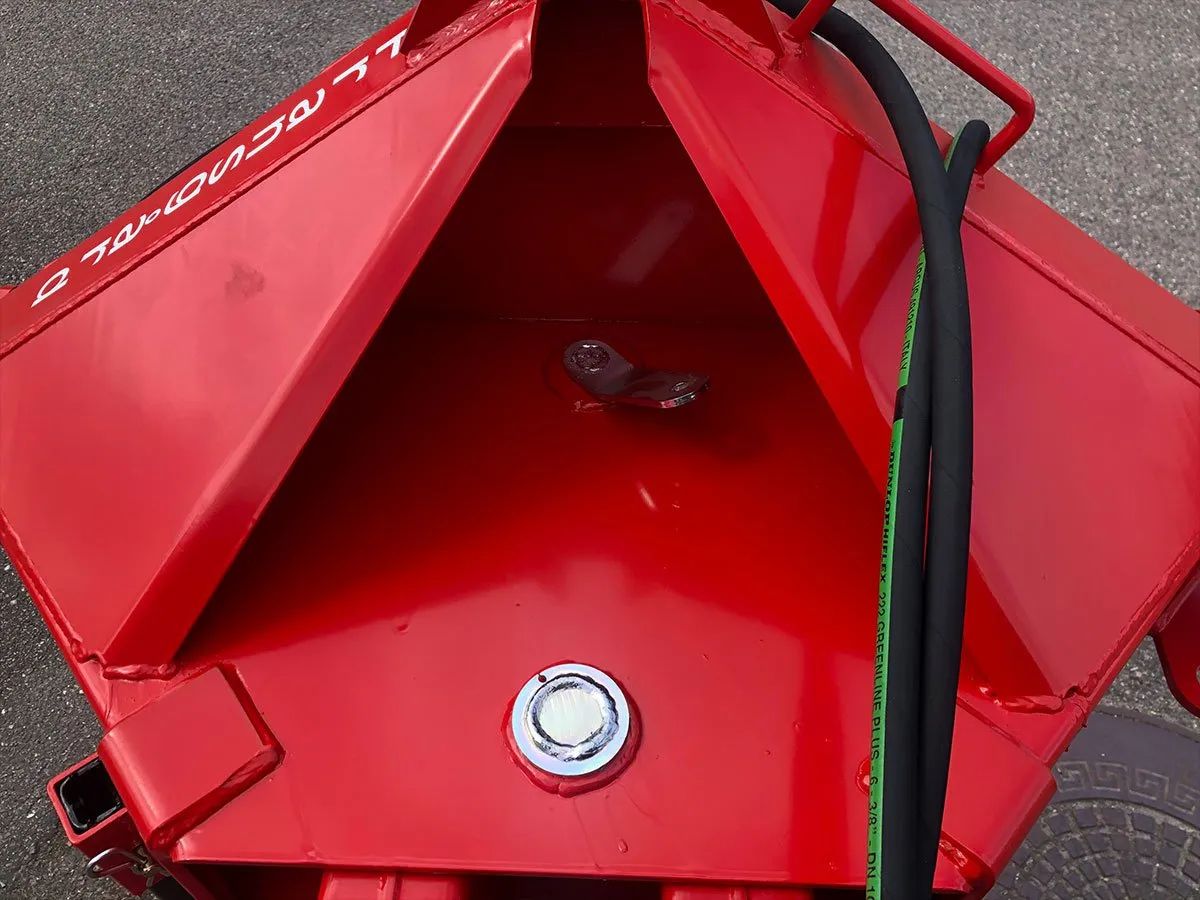 Ein roter Metallgegenstand, an dem ein Schlauch befestigt ist.