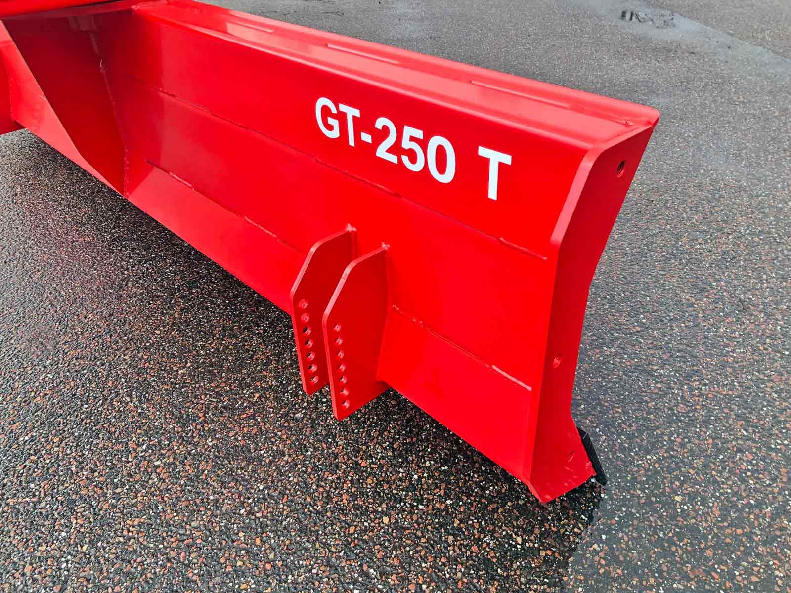 Auf dem Boden steht ein roter Schneepflug.