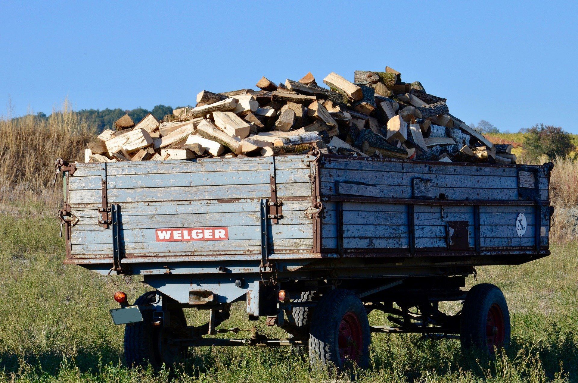 Ein blauer Anhänger mit viel Holz darin