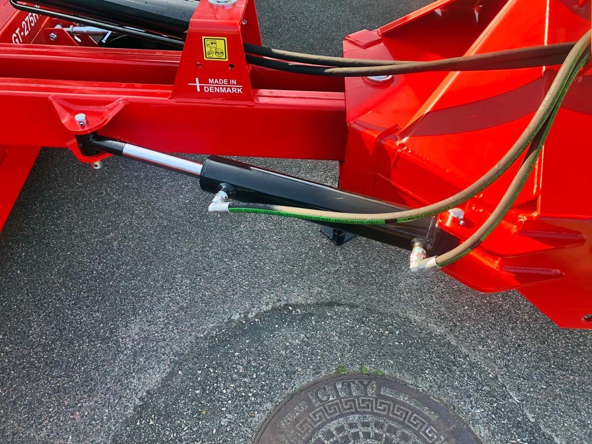 Ein roter Traktor steht am Straßenrand.