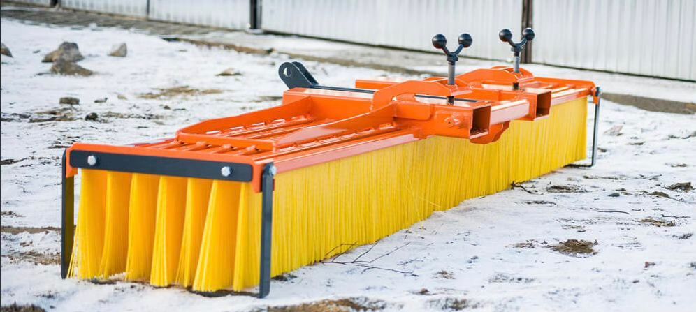 Eine Reihe orangefarbener Besen stehen am Straßenrand