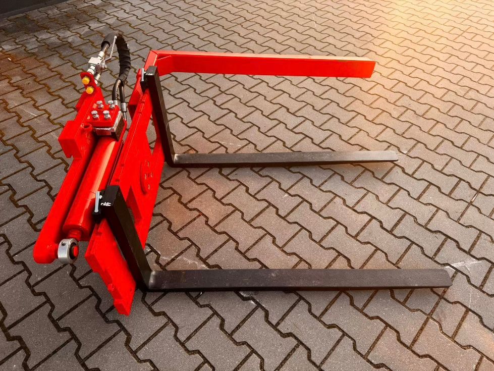 Roter Gabelstapleraufsatz auf einer gepflasterten Fläche.