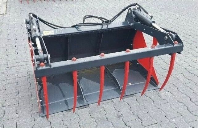 Ein großer Eimer mit roten und schwarzen Zähnen steht auf einem Ziegelboden