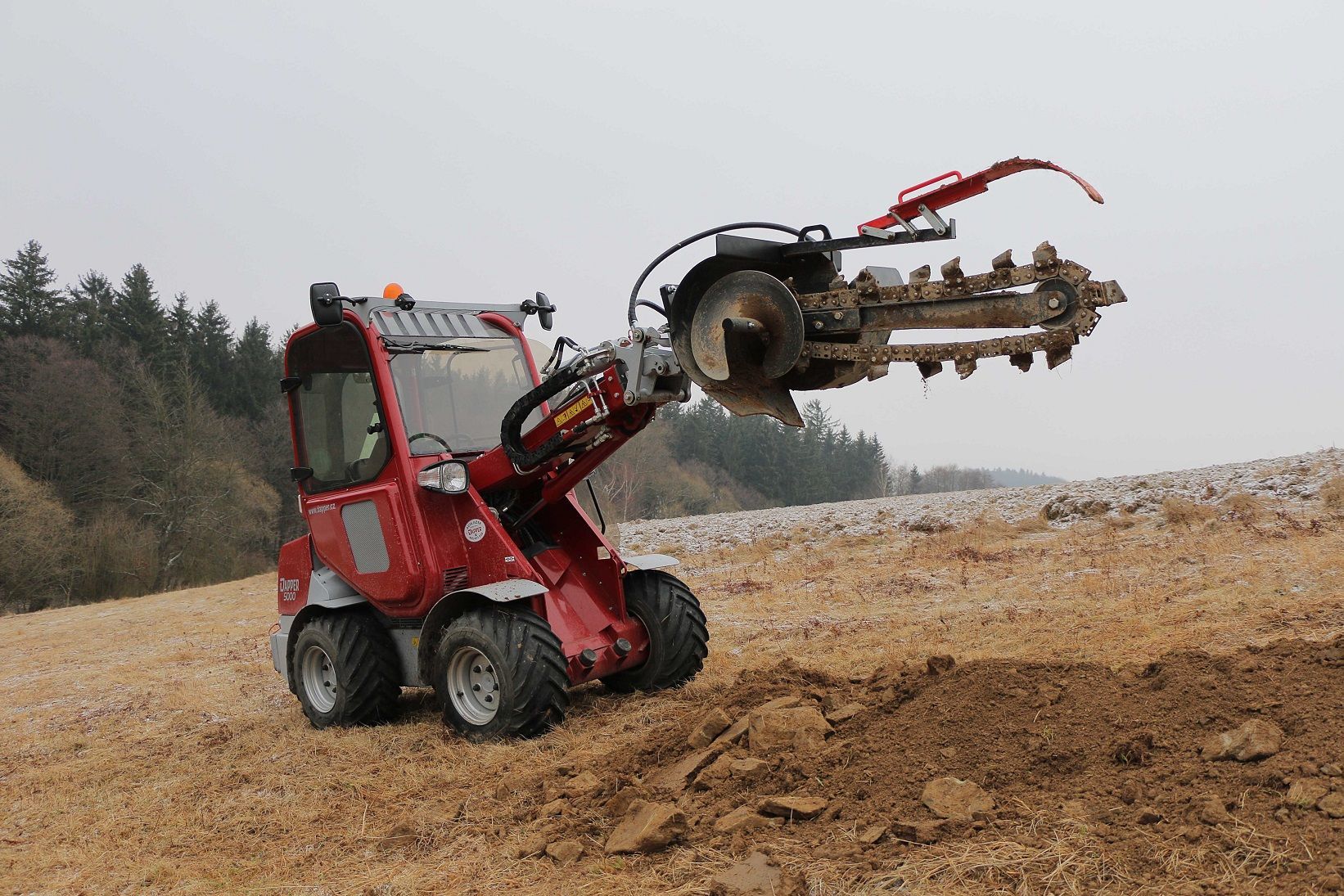 Ein roter Traktor fährt durch ein Feld.