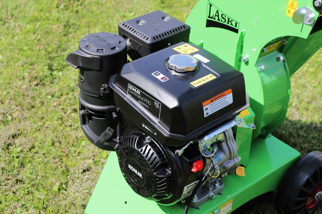 Eine grüne Maschine mit einem schwarzen Motor steht auf einem üppigen grünen Feld.
