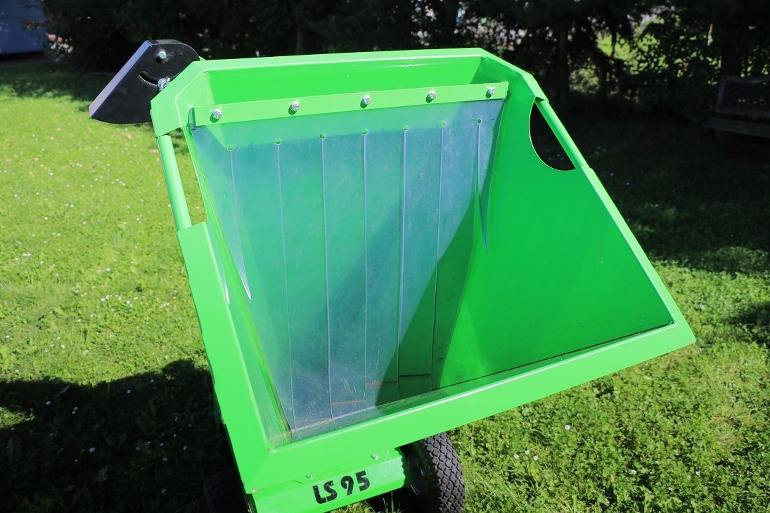Auf einem üppigen grünen Feld steht ein grüner Müllcontainer.