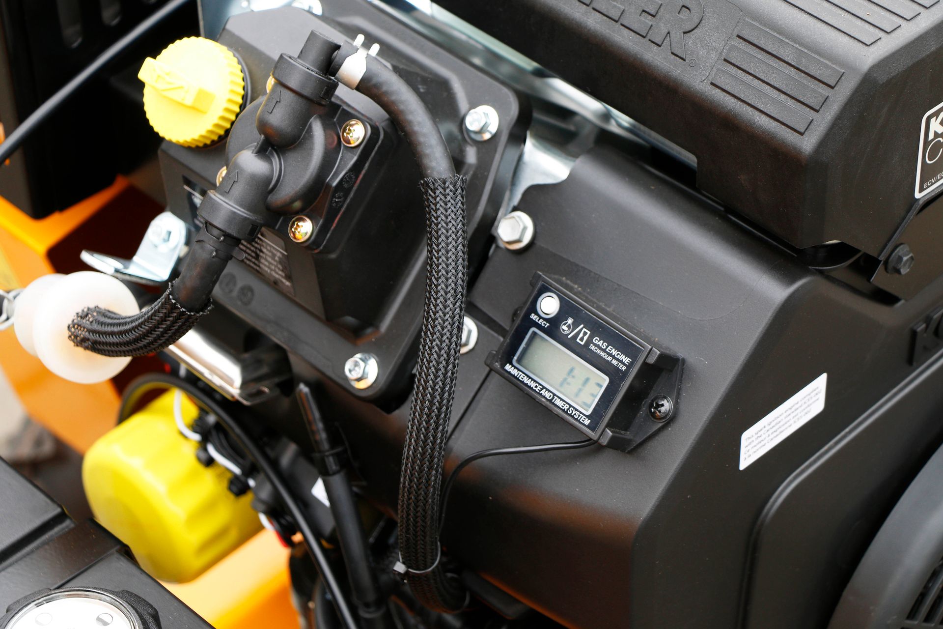 Eine Nahaufnahme eines Rasenmähermotors mit einem digitalen Drehzahlmesser
