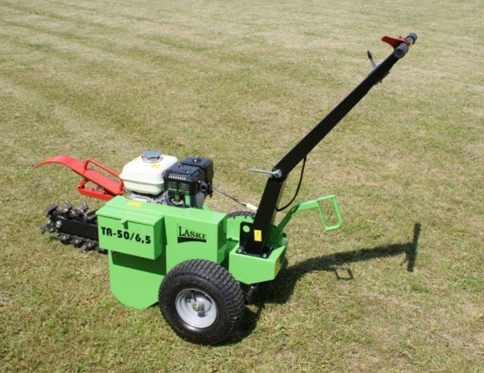 Ein grüner Rasenmäher steht auf einem üppigen grünen Feld