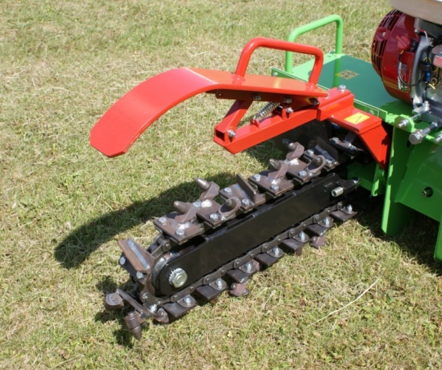 Eine grün-rote Maschine sitzt im Gras