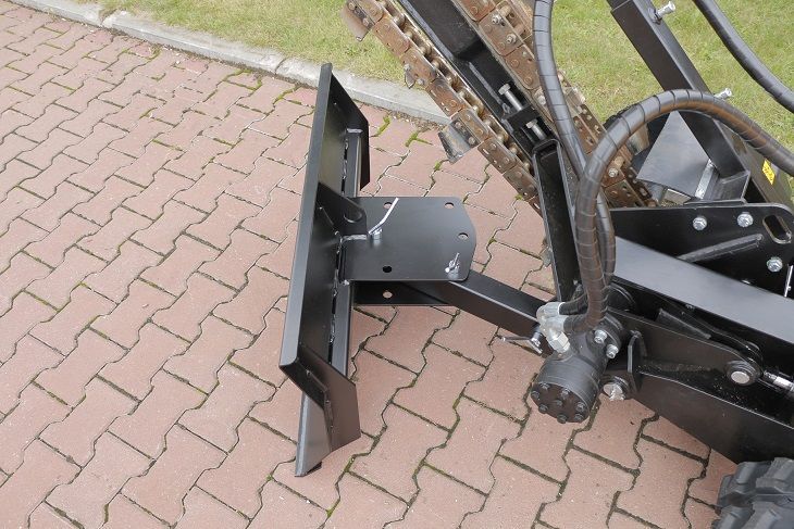 Eine schwarze Maschine steht auf einem gepflasterten Gehweg