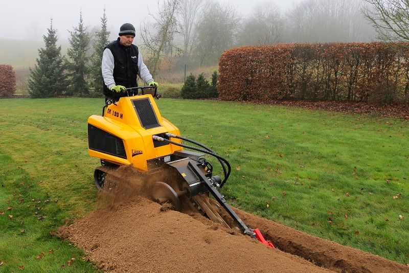 Ein Mann fährt einen gelben Traktor über einen üppigen grünen Rasen.