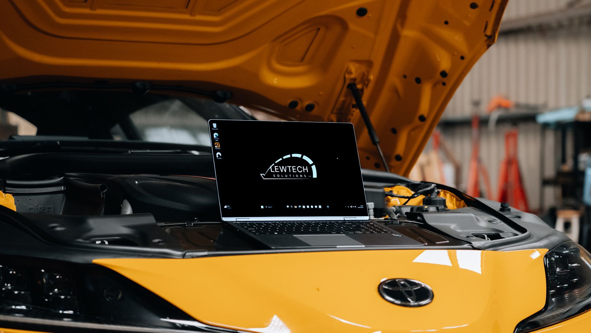 ECU remapping equipment connected to a yellow performance car