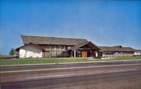 Low, modern building beside a highway under a blue sky