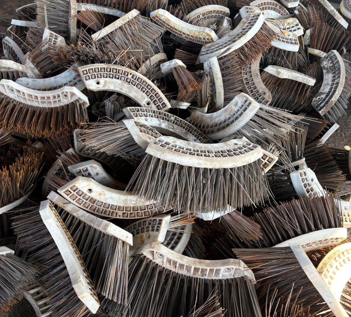 Pile of brown and white curved wire brushes stacked together