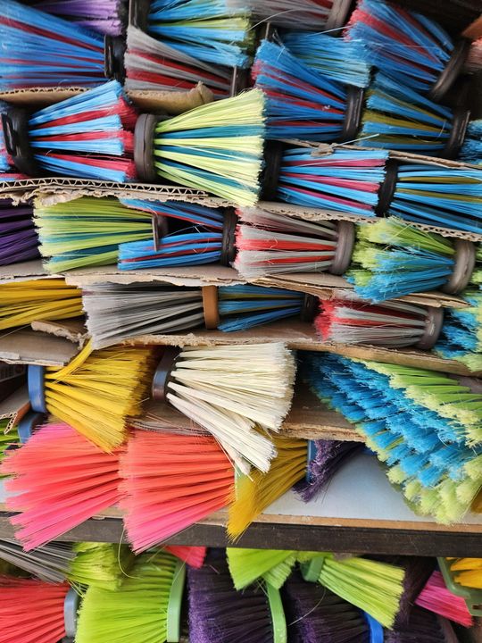 Stacked bundles of brightly colored incense sticks tied with twine on shelves.