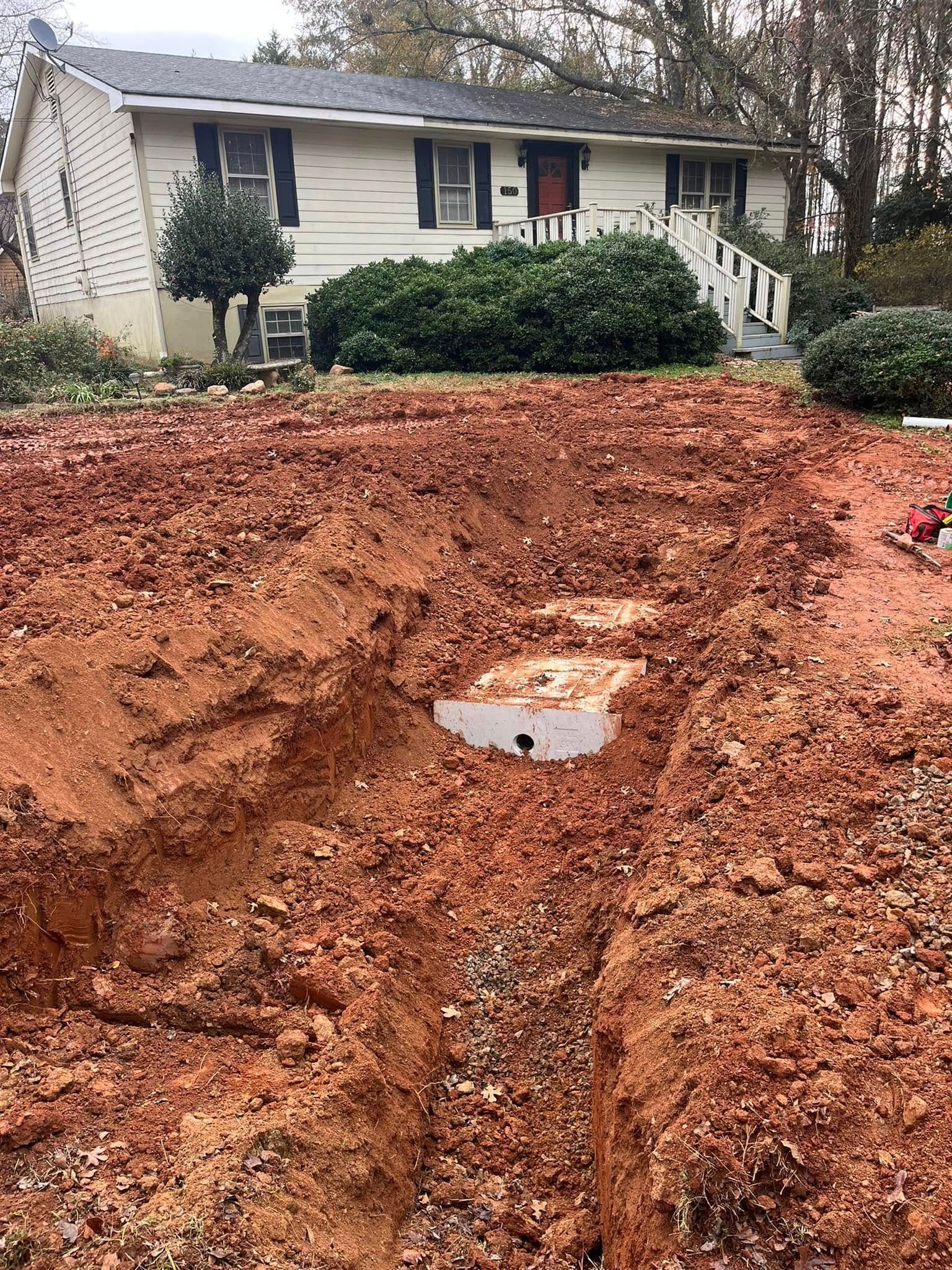 A large pile of dirt is in front of a house.