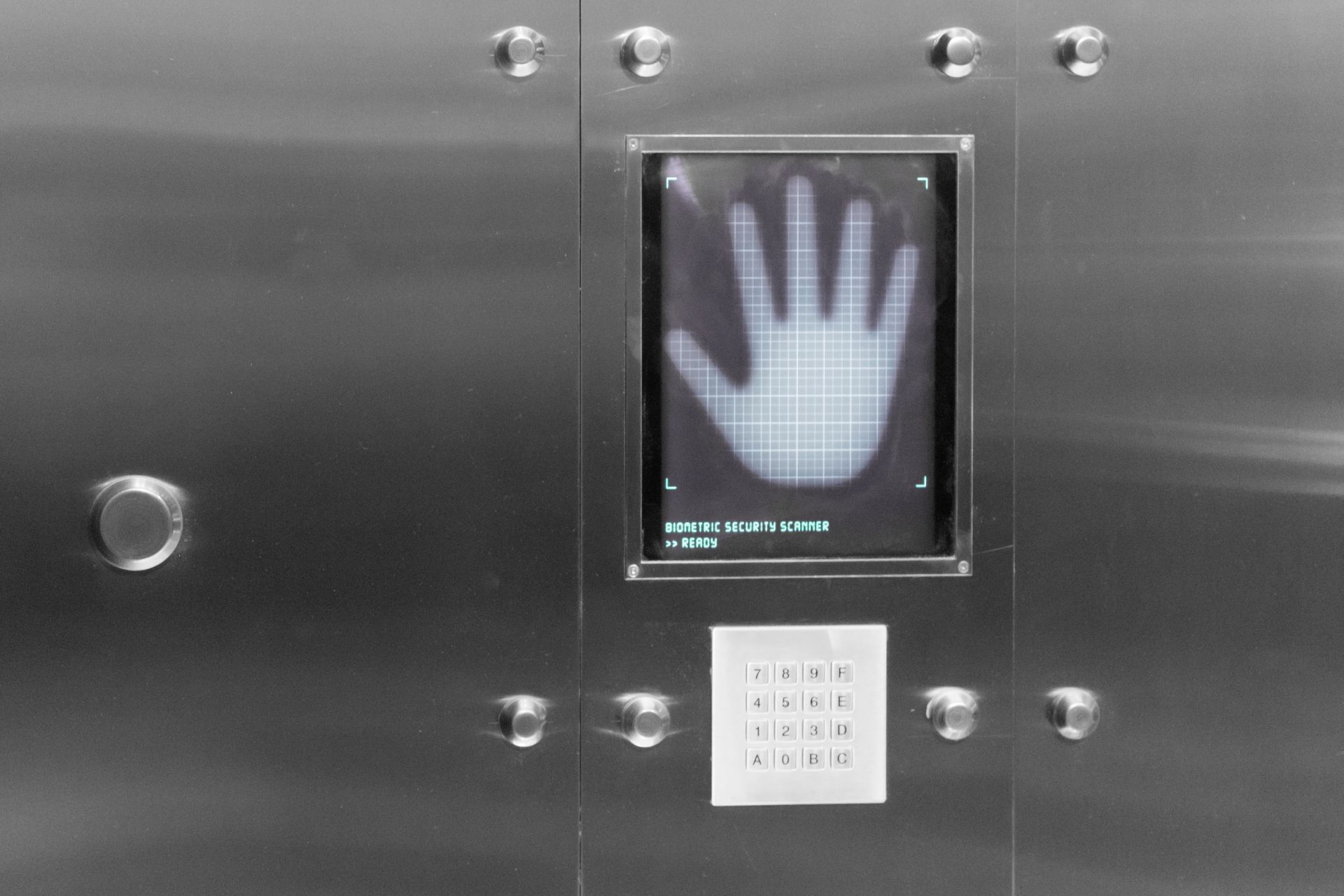 A stainless steel elevator with a picture of a hand on the screen.