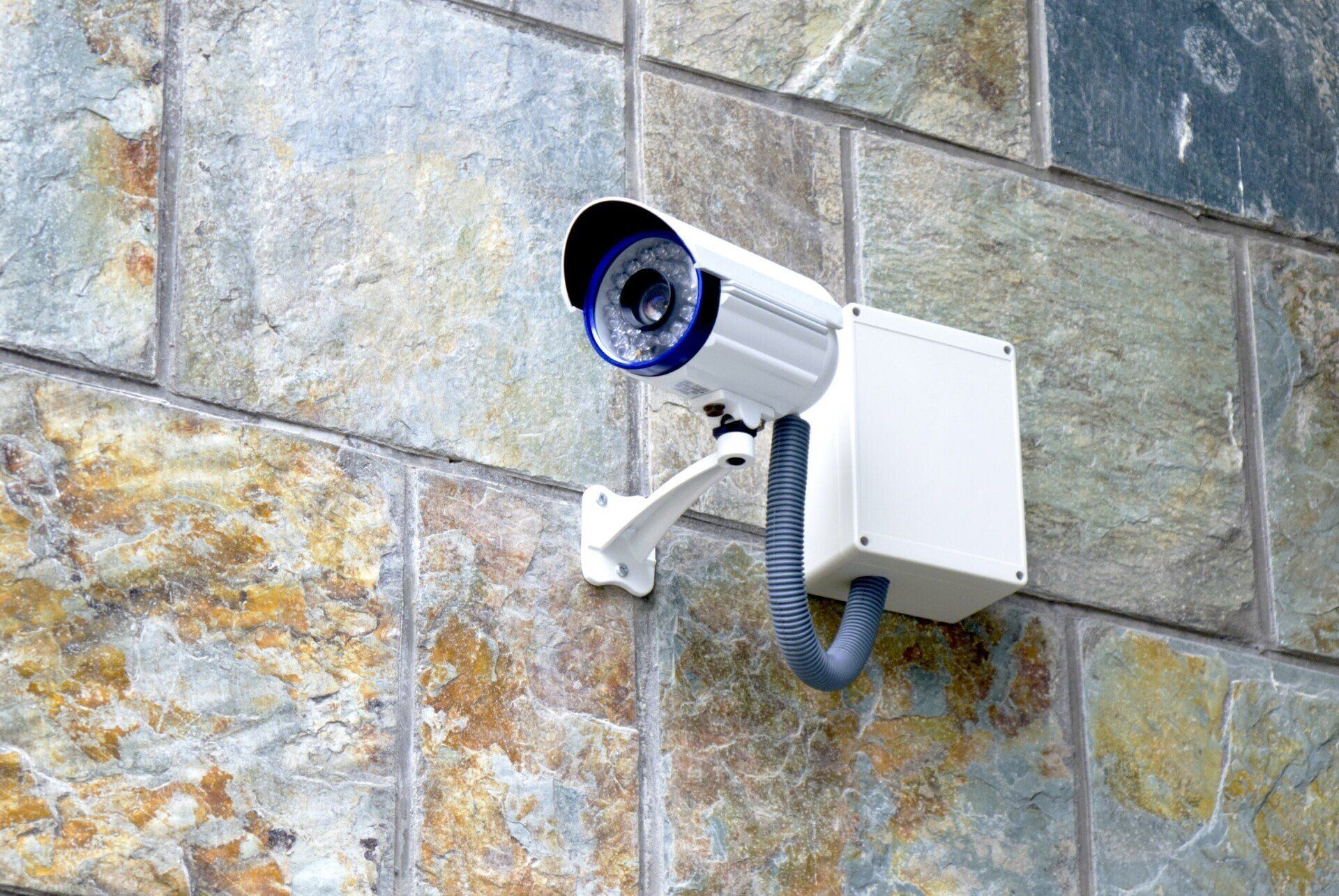 A security camera is mounted on a brick wall.