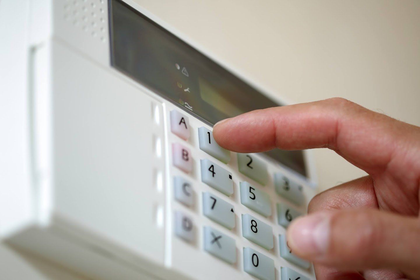 A person is pressing a button on a security system.
