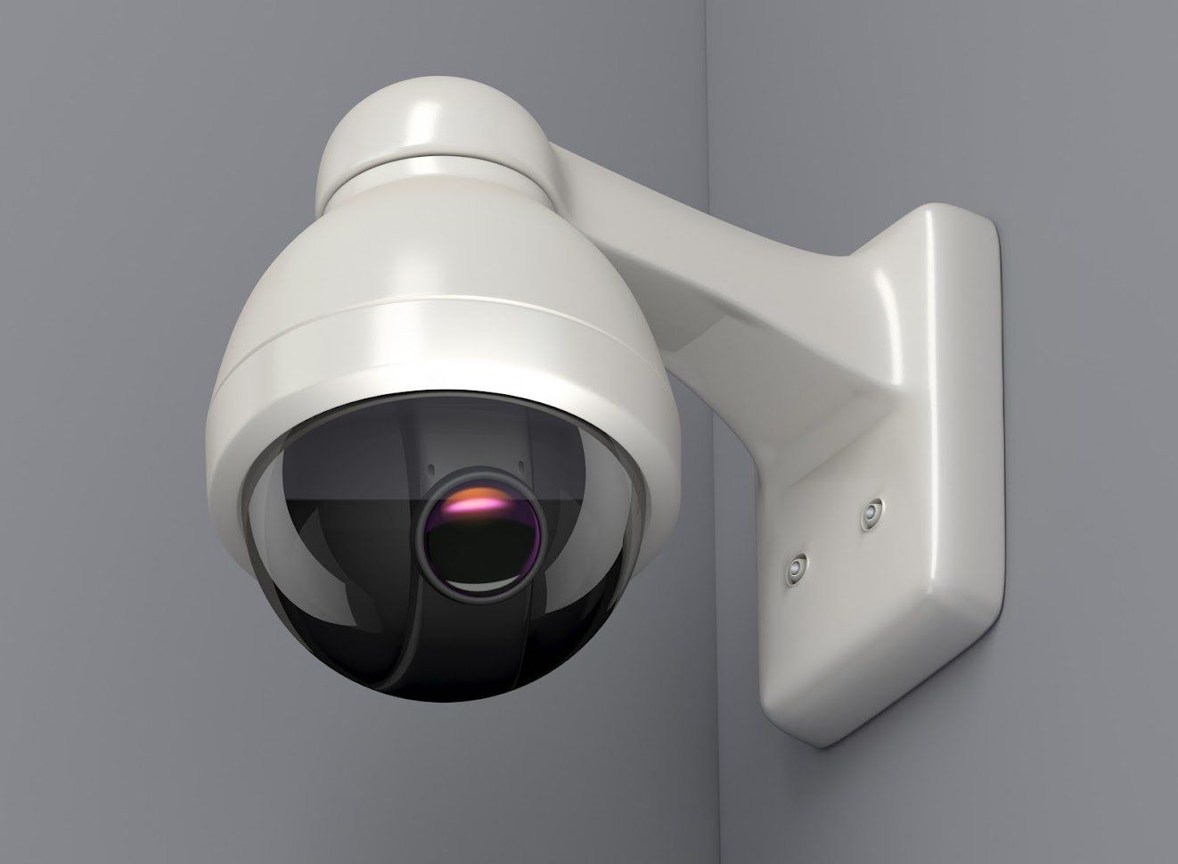 A security camera is mounted to a wall in a corner