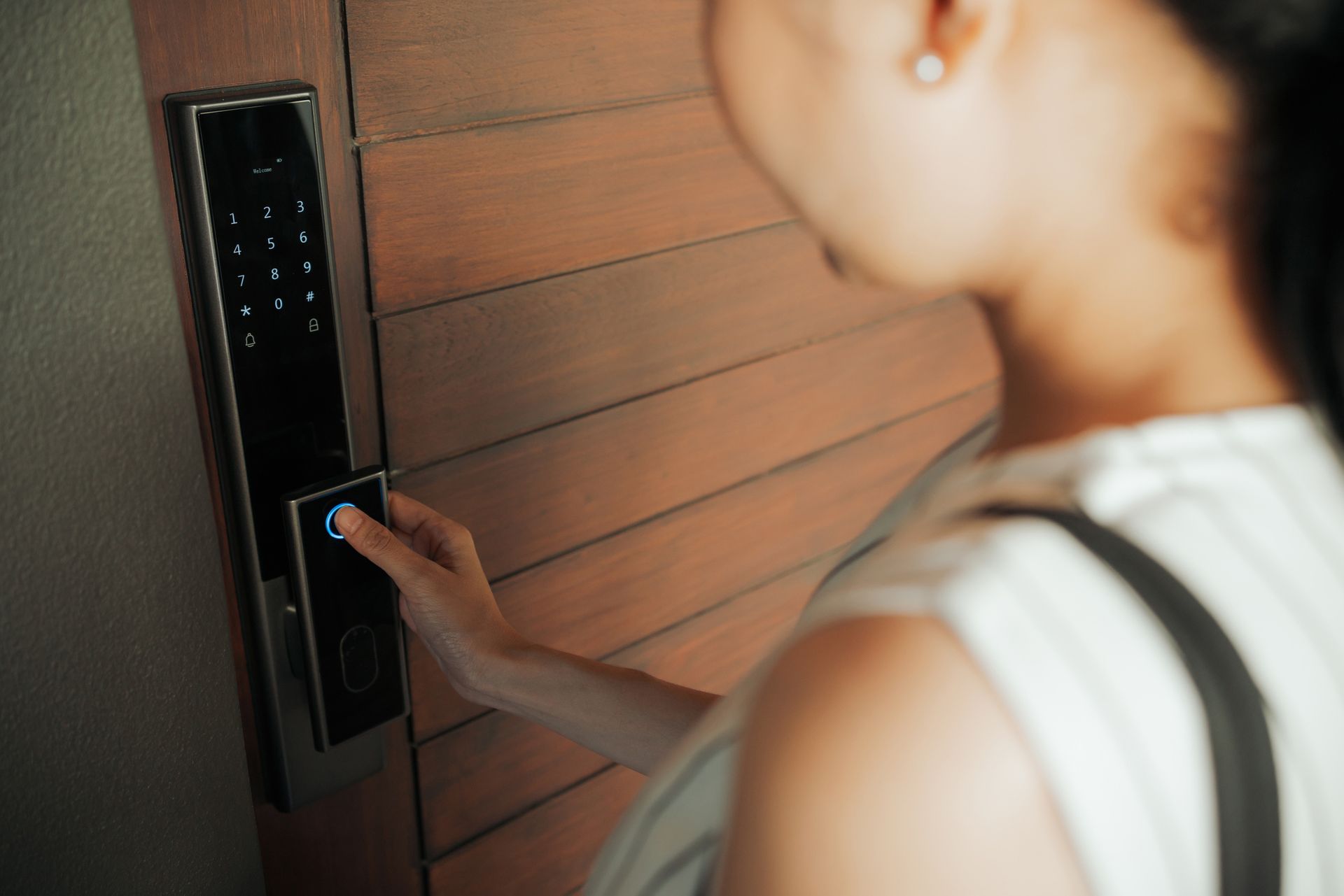 A woman pressing an electronic door panel, showcasing an access control system in action.