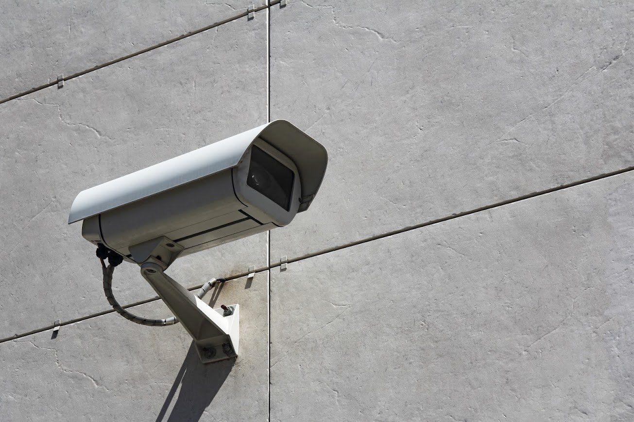 A security camera is mounted on the side of a building