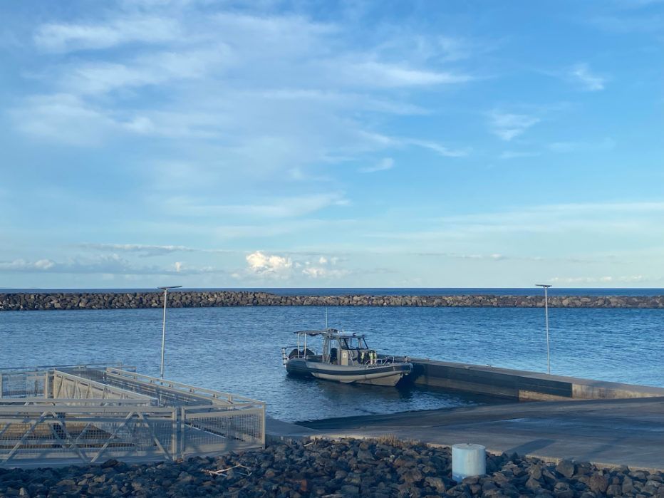 Moonshine boat docked at a Kawaihae Harbor with a blue sky in the background