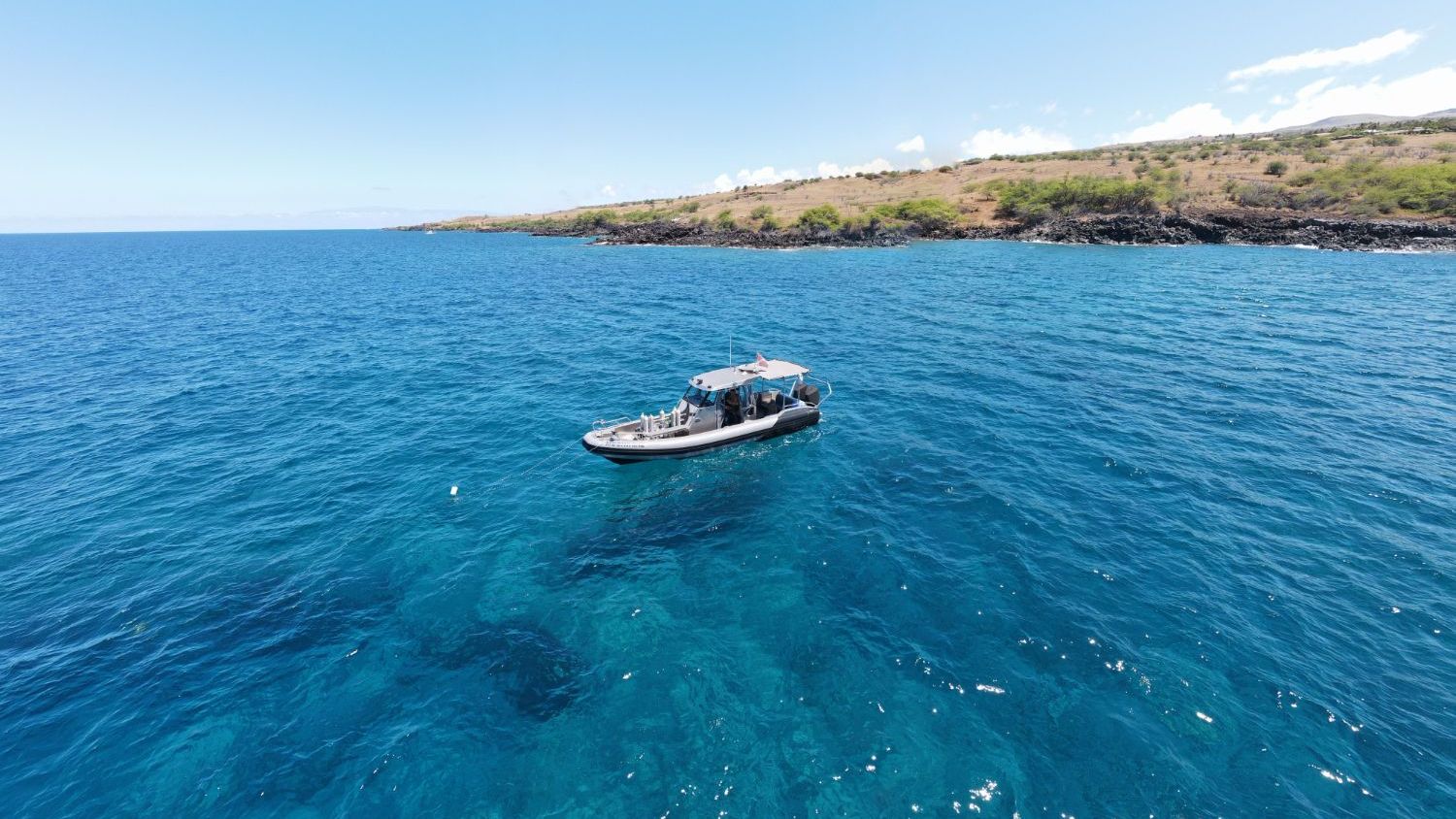 An aerial view of a boat in the middle of the ocean.