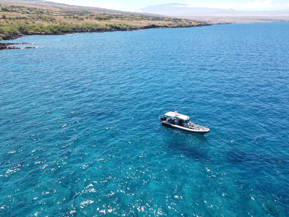 an aerial view of a boat in the ocean