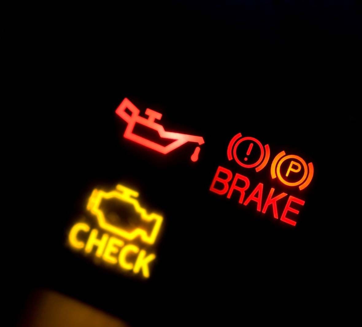 Dashboard warning lights: red brake alert and yellow check engine light on black background