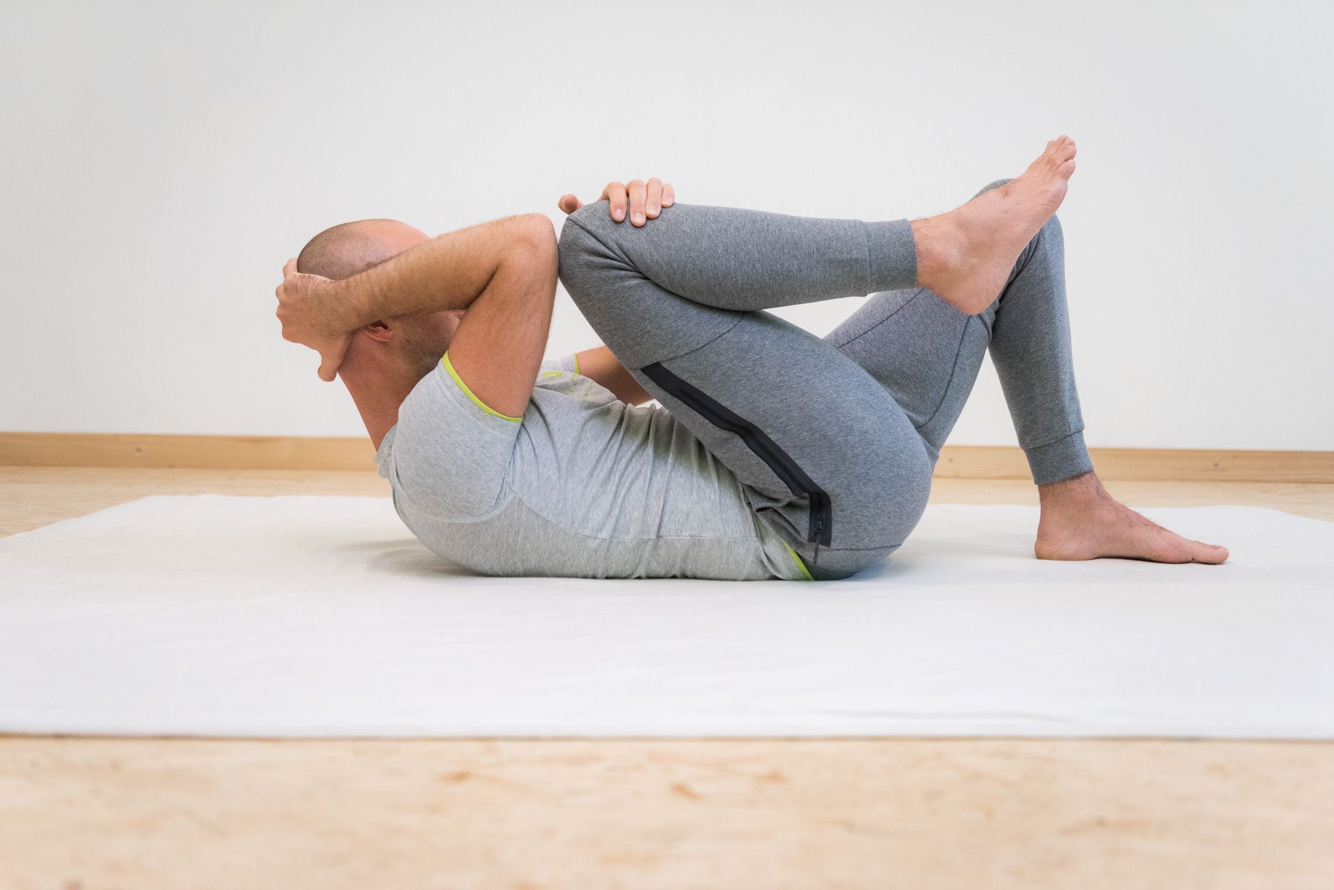 A person doing a muscle relaxation exercise on a gym mat.