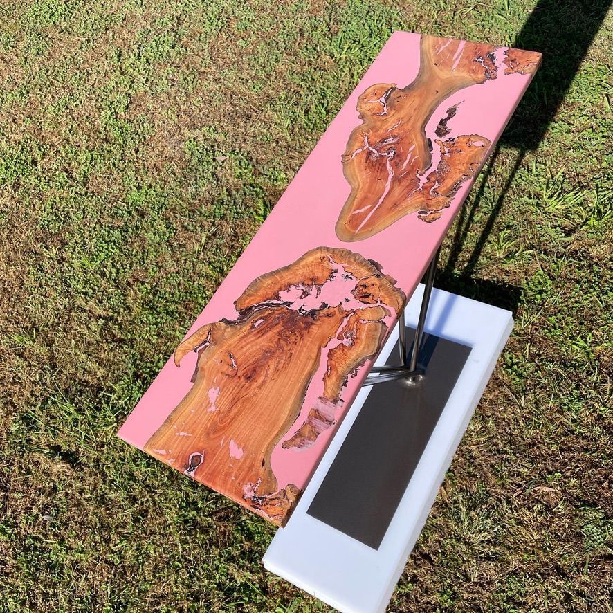 A custom pink and brown piece of wood crafted into a stand by Metal Wood and Things
