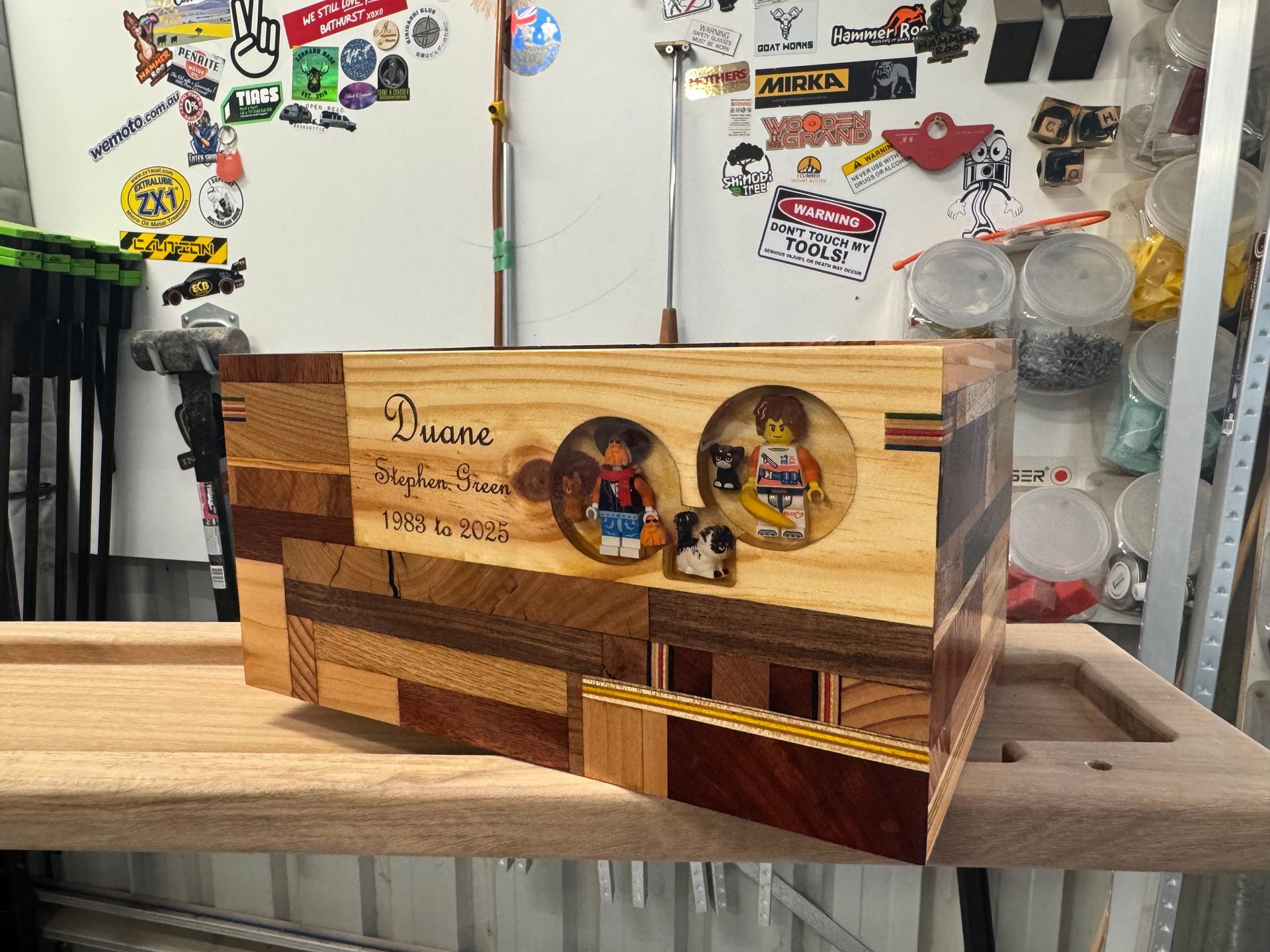 Wooden box with inlaid wood, Lego figures, and nameplate.