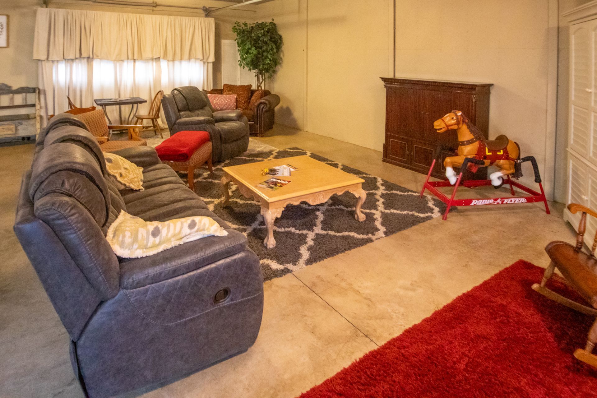 Living room with recliner, couches, rocking horse, and area rug.