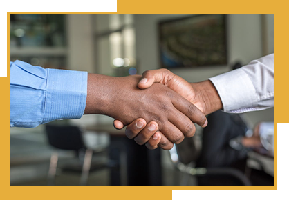 Two men are shaking hands in a room.