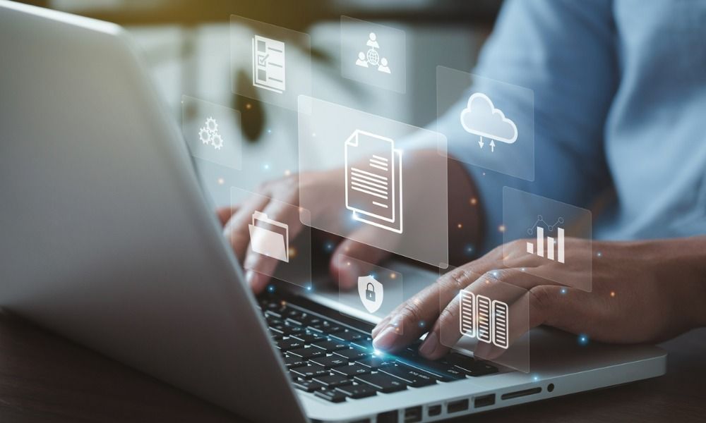 A person is typing on a laptop computer with icons coming out of it.